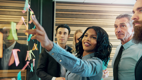 Woman adding post-it notes to a brainstorm wall